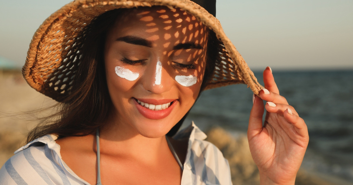 The woman has worn the hat and applied cream on her face